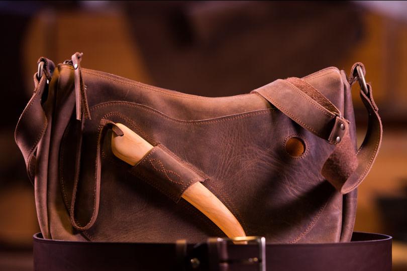 A leather bag with a bone slotted on the side of it